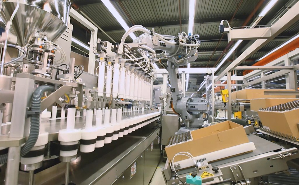 IWK tube filling machine showing loading of empty tubes