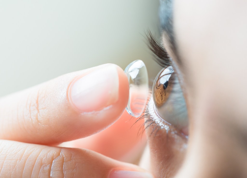 Eine Person, die sich eine Kontaktlinse ins Auge einsetzt