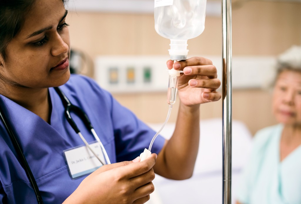 Nurse adjusting an IV tube set