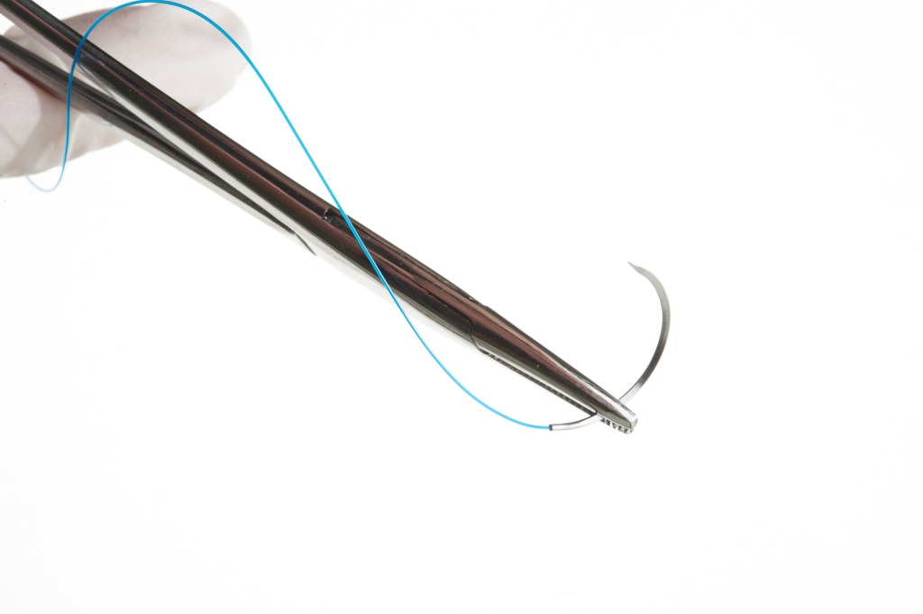 Tweezers holding a surgical suture