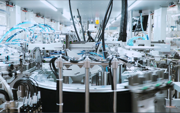 Vista interna di una macchina di assemblaggio automatizzato complessa che mostra diverse stazioni di produzione