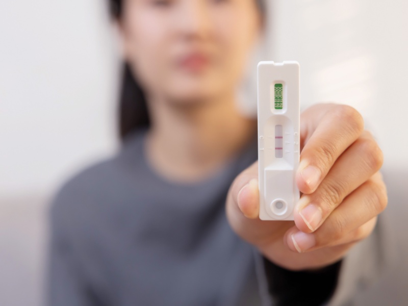 A woman holding a diagnostic test